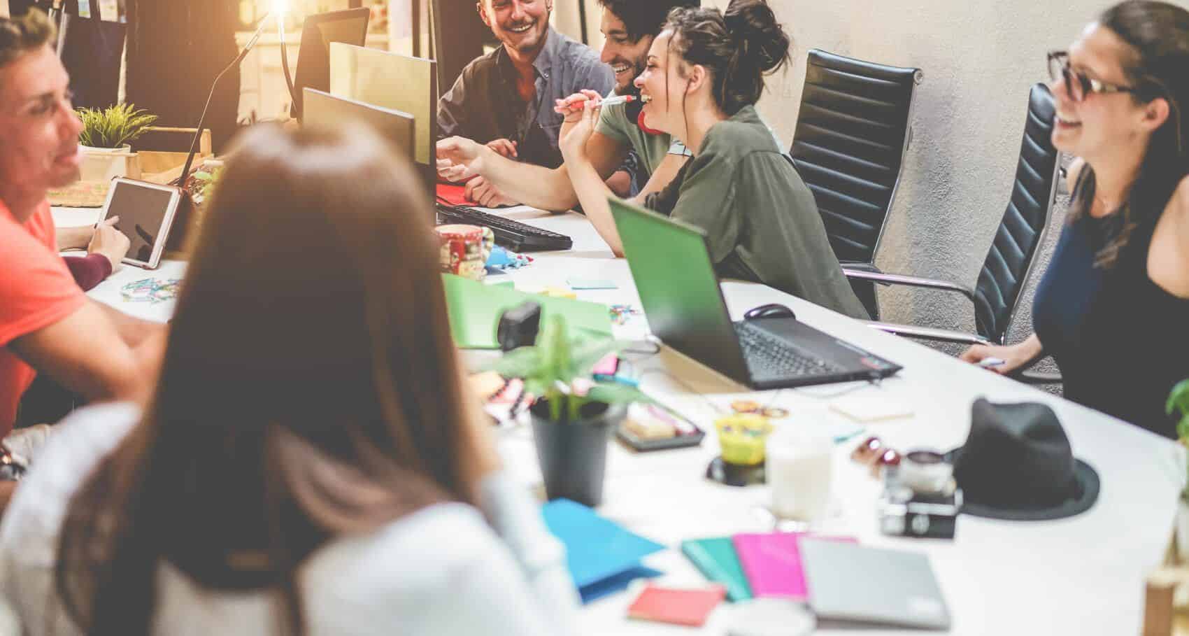 Junge Mitarbeiter, die sich während eines Meetings unterhalten - Symbolbild Marketingteam