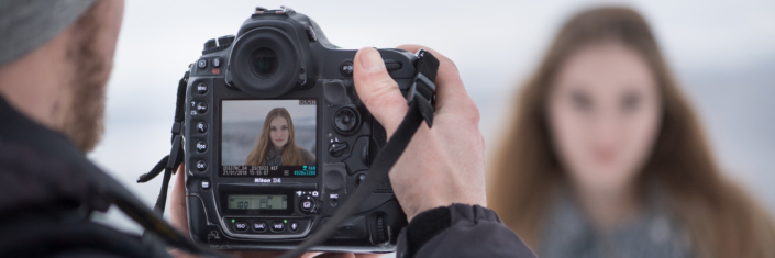 Fotograf fotografiert Fotomodell mit Digitalkamera über Display - Symbolbild Fotometadaten