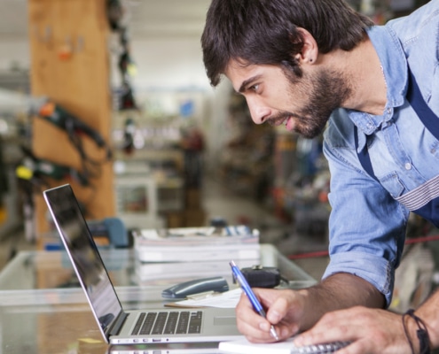 Mitarbeiter schaut am Laptop in Portal nach neuen Produkten - Symbolbild für Händlerportal / Produktportal