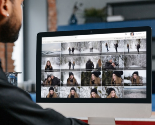 Mitarbeiter verwaltet Fotos auf Mac - Symbolbild Fotos einsammeln von Gruppen